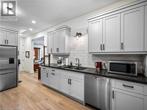 Kitchen on main-floor: double undermount sink, quartz countertops, patterned subway tile backsplash, Miele dishwasher - 213 Caroline Street S, Hamilton, ON 