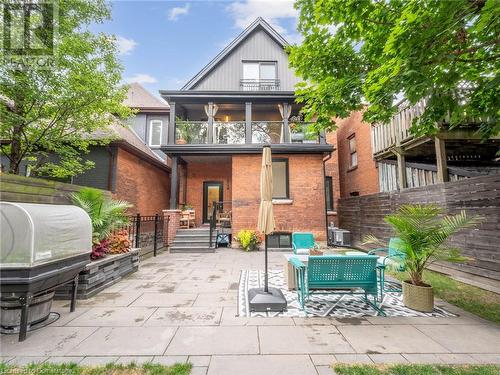 Large (and private) yard surrounded by mature trees, extensive patio with walkway, and fully fenced - 213 Caroline Street S, Hamilton, ON - Outdoor With Balcony