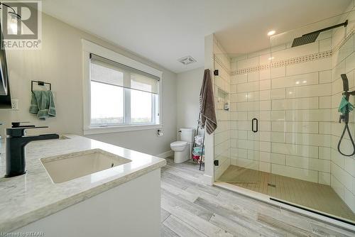 Bathroom with hardwood / wood-style floors, vanity, toilet, and a shower with door - 82 Sunview Drive, Norwich, ON - Indoor Photo Showing Bathroom