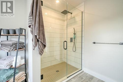 Bathroom featuring wood-type flooring and a shower with door - 82 Sunview Drive, Norwich, ON - Indoor Photo Showing Bathroom