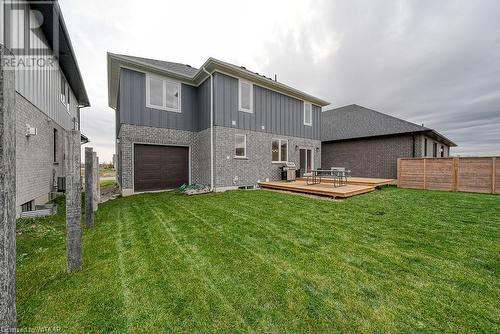 Back of property featuring central AC unit, a garage, a lawn, and a deck - 82 Sunview Drive, Norwich, ON - Outdoor With Exterior