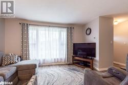 Living room with a textured ceiling and light hardwood / wood-style floors - 