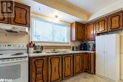 Kitchen with sink and white range with electric cooktop - 