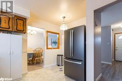 Kitchen with pendant lighting, white refrigerator, stainless steel refrigerator, and light hardwood / wood-style flooring - 