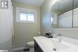 Bathroom featuring walk in shower, vanity, and toilet - 