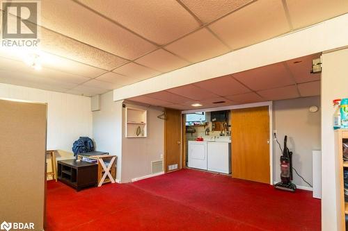 Basement featuring washing machine and dryer, a drop ceiling, and dark carpet - 262 Barrett Boulevard, Napanee, ON - Indoor Photo Showing Other Room