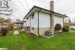 View of property exterior featuring central AC, a lawn, and a deck - 