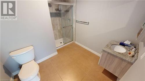 Bathroom featuring toilet, vanity, tile patterned flooring, and a shower with shower door - 308 Lester Street Unit# 215, Waterloo, ON - Indoor Photo Showing Bathroom