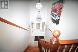 Stairs featuring wood-type flooring and a chandelier - 