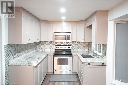 Kitchen featuring white cabinetry, appliances with stainless steel finishes, sink, and dark hardwood / wood-style floors - 30 Kristi Place, Kitchener, ON - Indoor Photo Showing Kitchen With Upgraded Kitchen