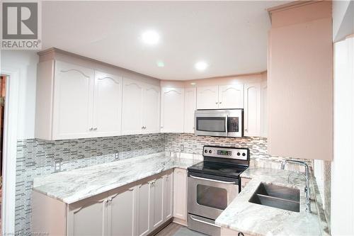 Kitchen featuring white cabinetry, appliances with stainless steel finishes, sink, and light stone counters - 30 Kristi Place, Kitchener, ON - Indoor Photo Showing Kitchen With Double Sink With Upgraded Kitchen