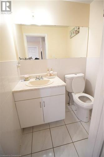 Bathroom featuring toilet, vanity, tile walls, and tile patterned floors - 30 Kristi Place, Kitchener, ON - Indoor Photo Showing Bathroom