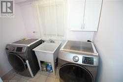 Laundry room with light tile patterned floors and sink - 