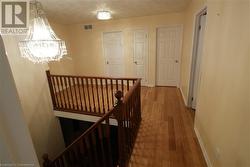 Corridor with hardwood / wood-style floors and a textured ceiling - 