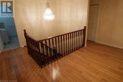 Staircase with hardwood / wood-style flooring and a chandelier - 