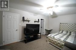 Carpeted bedroom featuring ceiling fan and a textured ceiling - 