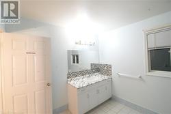 Bathroom with backsplash, vanity, and tile patterned flooring - 