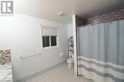 Bathroom with toilet, decorative backsplash, vanity, and tile patterned floors - 