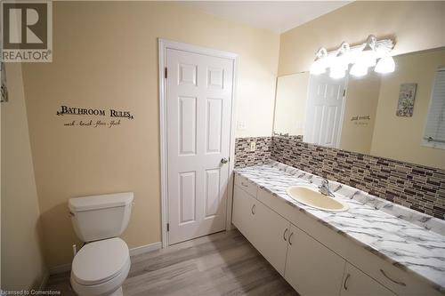 Bathroom featuring toilet, tasteful backsplash, vanity, and hardwood / wood-style floors - 30 Kristi Place, Kitchener, ON - Indoor Photo Showing Bathroom