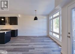 Kitchen featuring hanging light fixtures, light hardwood / wood-style floors, and wall chimney range hood - 