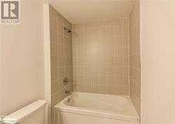 Bathroom with tiled shower / bath and toilet - 