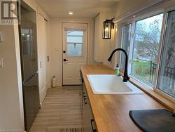 Kitchen with butcher block counters, light wood-type flooring, and sink - 