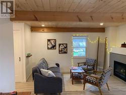 Living room featuring beam ceiling, a tile fireplace and wood ceiling - 