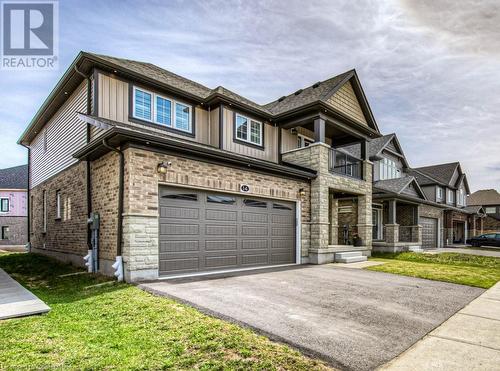 View of front of house with a garage, a front lawn, and a balcony - 14 Greyhawk Street, Kitchener, ON - Outdoor With Facade