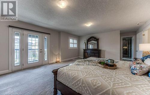 Bedroom featuring access to exterior, multiple windows, and a textured ceiling - 14 Greyhawk Street, Kitchener, ON - Indoor Photo Showing Bedroom