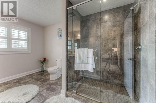 Bathroom featuring a textured ceiling, toilet, and an enclosed shower - 14 Greyhawk Street, Kitchener, ON - Indoor Photo Showing Bathroom