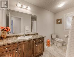 Bathroom with vanity, a textured ceiling, and toilet - 