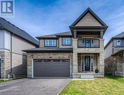 View of front of house featuring a garage, a front lawn, and a balcony - 