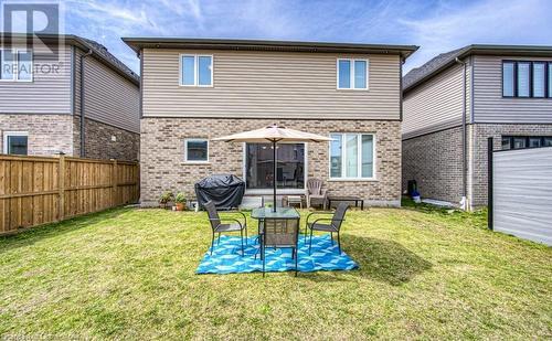 Rear view of property featuring a lawn, a patio, and a garage - 14 Greyhawk Street, Kitchener, ON - Outdoor With Exterior