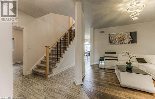 Living room featuring hardwood / wood-style floors, a notable chandelier, and a textured ceiling - 14 Greyhawk Street, Kitchener, ON - Indoor Photo Showing Living Room