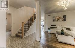 Living room featuring hardwood / wood-style floors, a notable chandelier, and a textured ceiling - 