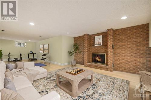 Virtually staged lower family room - 4 Timbercrest Ridge, Ottawa, ON - Indoor Photo Showing Living Room With Fireplace