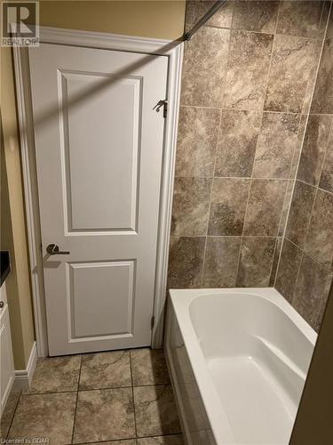 Bathroom featuring tub / shower combination, vanity, and tile patterned flooring - 111 Dallan Drive, Guelph, ON - Indoor Photo Showing Bathroom