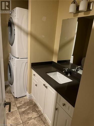 Bathroom featuring stacked washer / drying machine, vanity, and tile patterned floors - 111 Dallan Drive, Guelph, ON - Indoor Photo Showing Laundry Room