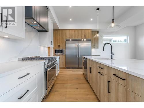 This kitchen offers loads of counter space, with high-end appliances and quartz countertops - 907 Bull Crescent Lot# 91, Kelowna, BC - Indoor Photo Showing Kitchen With Upgraded Kitchen