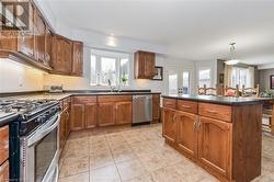 Kitchen featuring french doors, stainless steel appliances, a center island, sink, and decorative light fixtures - 