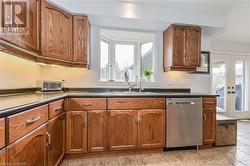 Kitchen with french doors, plenty of natural light, stainless steel dishwasher, and sink - 