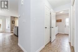 Hallway featuring washing machine and dryer, a healthy amount of sunlight, and light tile patterned flooring - 