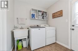 Clothes washing area with independent washer and dryer and light tile patterned flooring - 