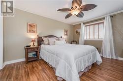 Bedroom featuring ornamental molding, wood-type flooring, and ceiling fan - 