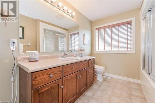 Full bathroom with enclosed tub / shower combo, tile patterned floors, vanity, and toilet - 43 Marr Drive, Elora, ON - Indoor Photo Showing Bathroom