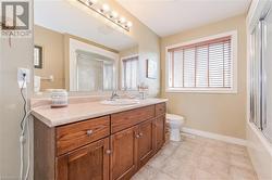 Full bathroom with enclosed tub / shower combo, tile patterned floors, vanity, and toilet - 