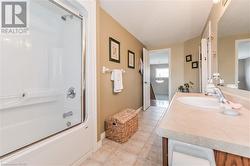 Bathroom featuring tile patterned flooring, shower / bath combination with glass door, and vanity - 