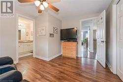 Living room with dark wood-type flooring, sink, and ceiling fan - 