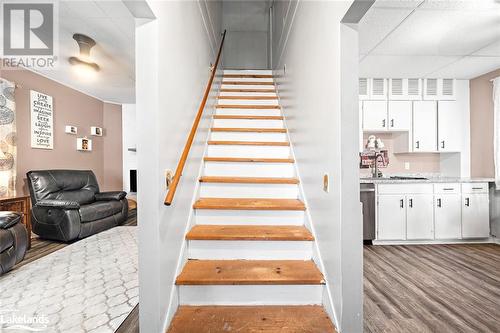 Stairway featuring a paneled ceiling, sink, and wood-type flooring - 97 William Street, Parry Sound, ON - Indoor