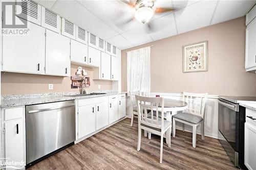 Kitchen with white cabinets, hardwood / wood-style flooring, stainless steel appliances, and sink - 97 William Street, Parry Sound, ON - Indoor Photo Showing Other Room